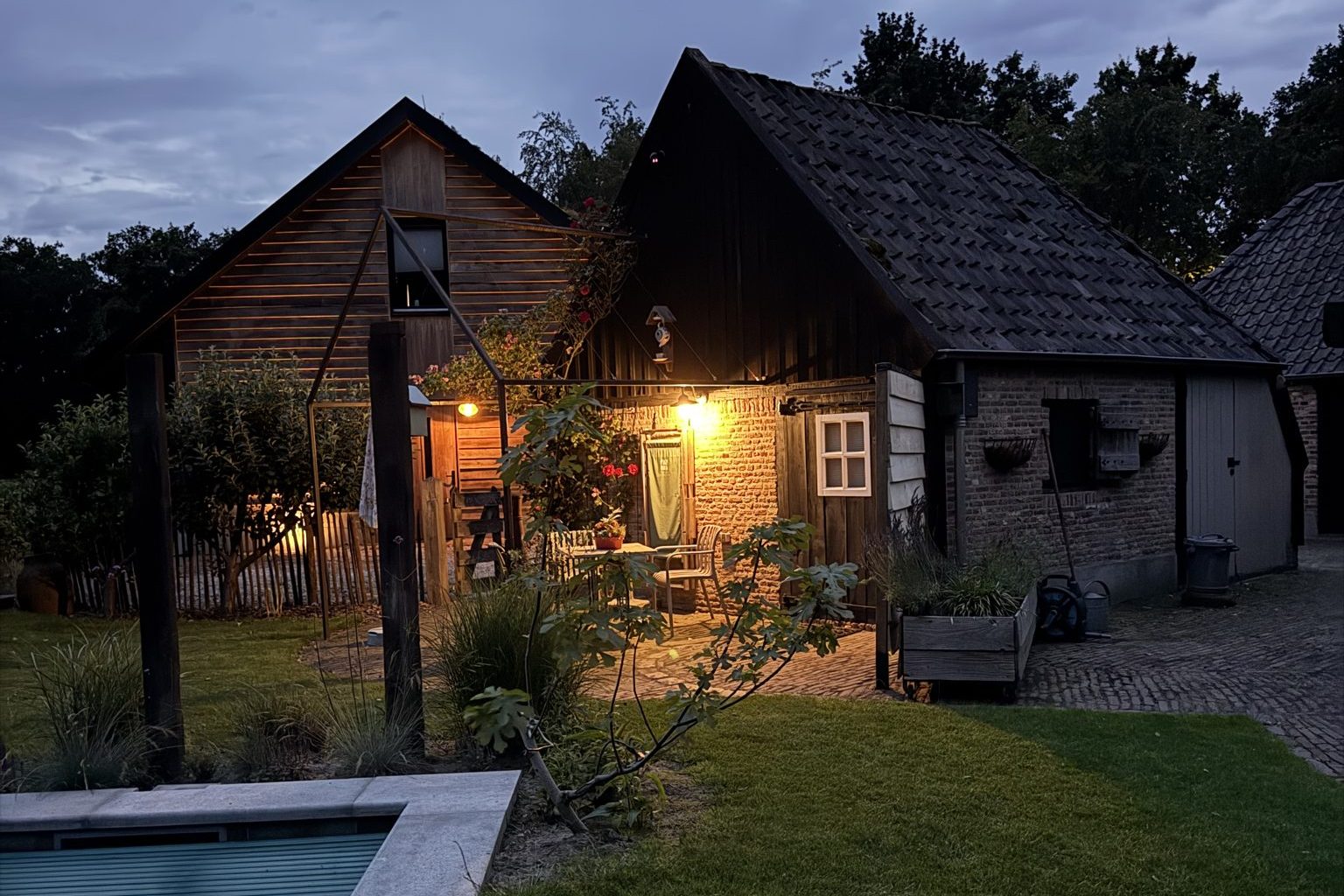 Sfeervol verlicht terras bij het Bakhuisje op Buitengoed de Bollen in de avond